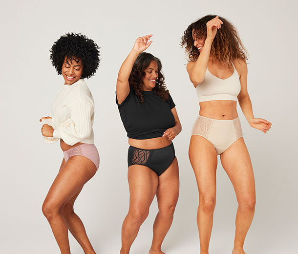 Drei Frauen tanzen in verschiedenen Modellen der waschbaren und schützenden TENA Silhouette Inkontinenzunterwäsche vor hellem, neutralem Hintergrund.