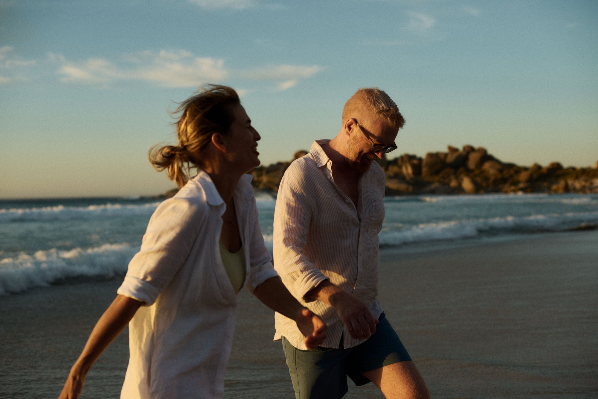 Paar genießt einen Spaziergang am Strand bei Sonnenuntergang