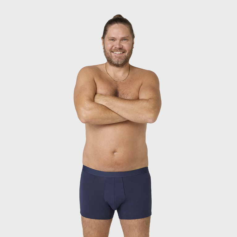 NEUE TENA Men Schützende Boxershorts an einem Mann mit verschränkten Armen.