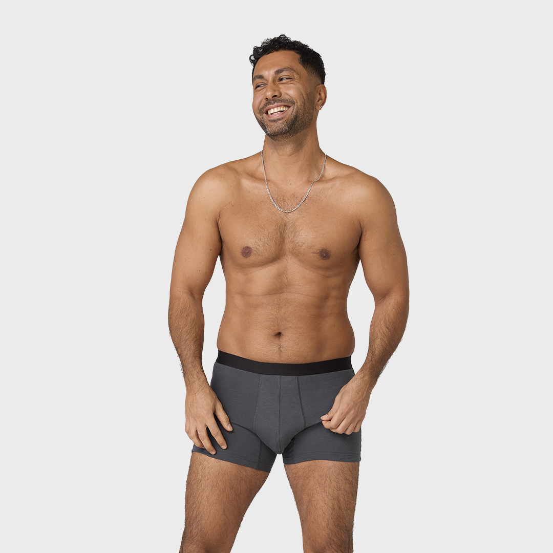 NEUE TENA Men schützende Boxershorts, getragen von lächelndem Mann.