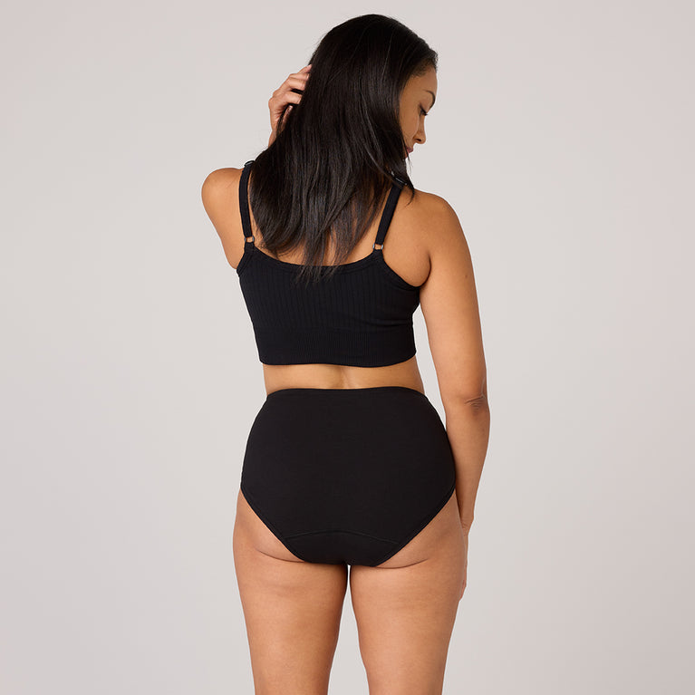 Frau trägt TENA 3-er Pack schützende Unterwäsche Bio-Baumwolle.